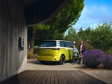 Volkswagen ID. Buzz Geel Schuinachterkant Bij Een Laadpaal In Een Tuin